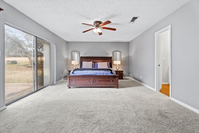 bedroom featuring ceiling fan, light colored carpet, access to exterior, and a textured ceiling