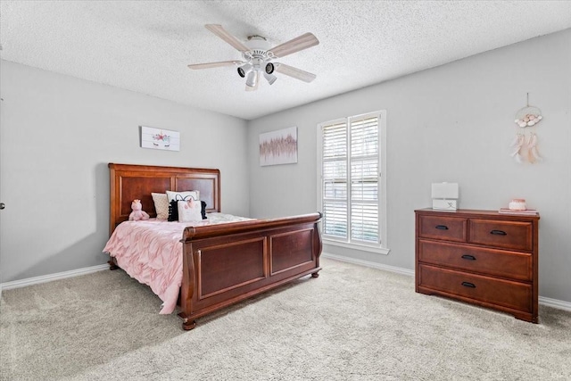 carpeted bedroom featuring ceiling fan and a textured ceiling