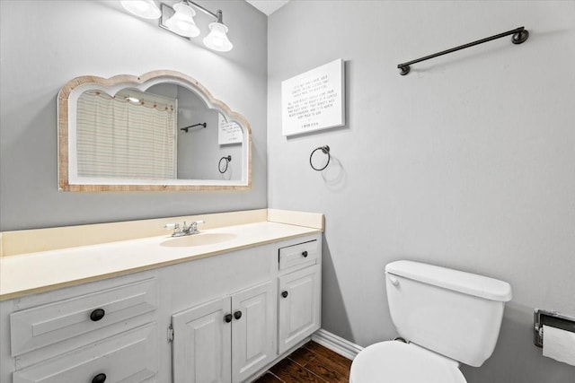 bathroom with vanity, wood-type flooring, and toilet