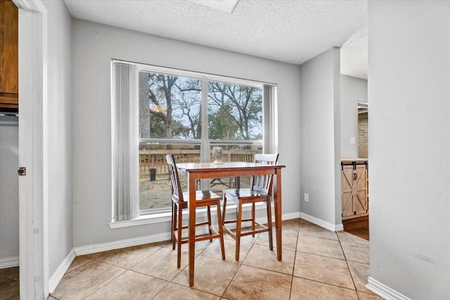 tiled dining space with a textured ceiling