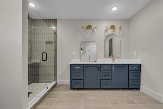 full bathroom with a sink, a shower stall, baseboards, and double vanity