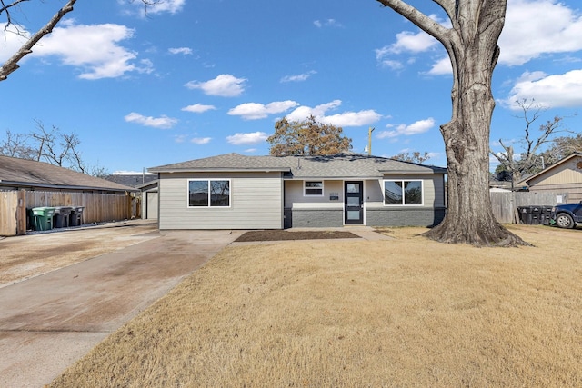 single story home with concrete driveway, brick siding, a front yard, and fence