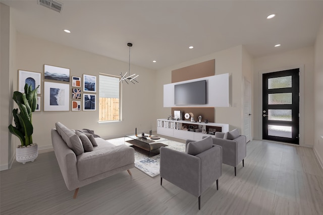 living room with a chandelier and light hardwood / wood-style floors