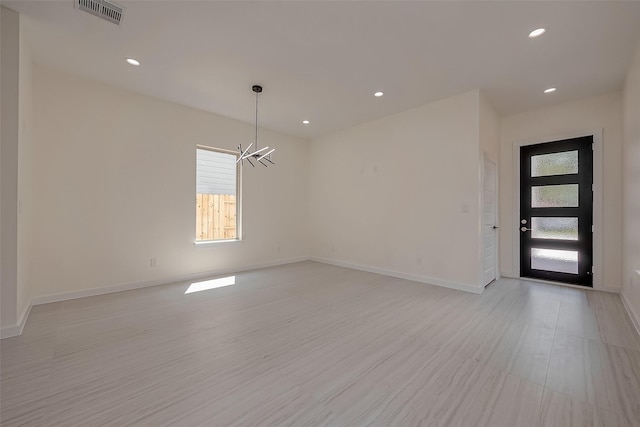 interior space featuring light hardwood / wood-style flooring and a notable chandelier