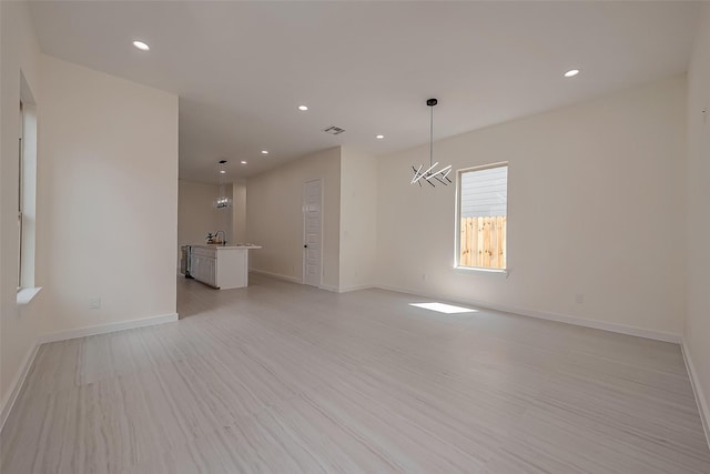 unfurnished room featuring sink and light hardwood / wood-style floors