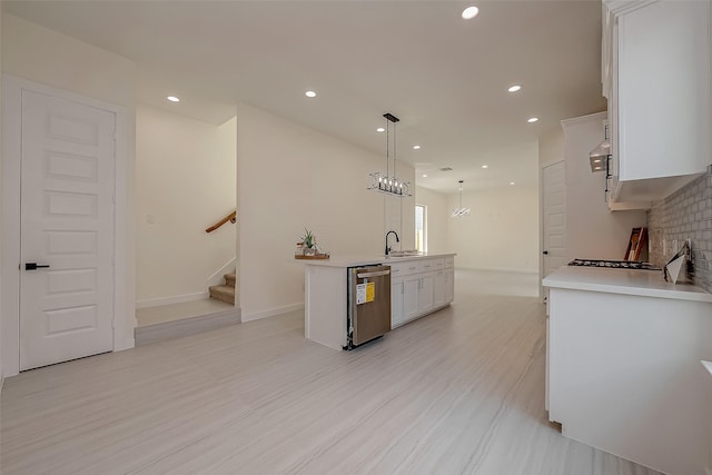 kitchen featuring white cabinetry, sink, backsplash, hanging light fixtures, and stainless steel dishwasher