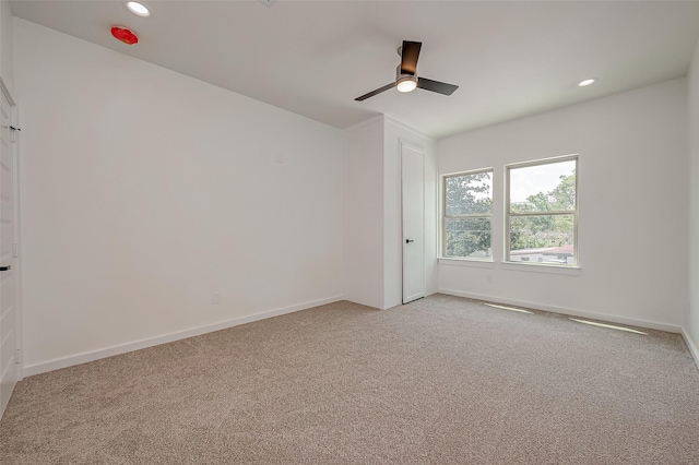 unfurnished room featuring ceiling fan and light colored carpet