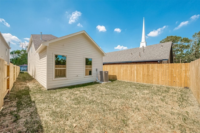 back of house featuring central AC and a yard