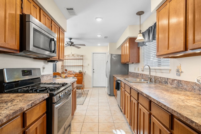 kitchen with sink, light tile patterned floors, pendant lighting, ceiling fan, and stainless steel appliances