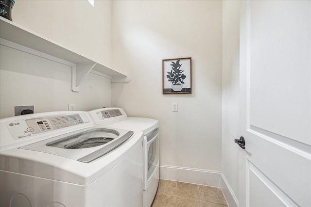 laundry area with light tile patterned flooring and washer and clothes dryer