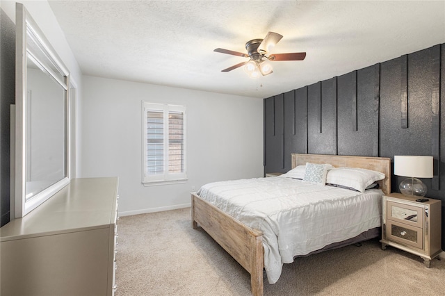 carpeted bedroom featuring ceiling fan and a textured ceiling