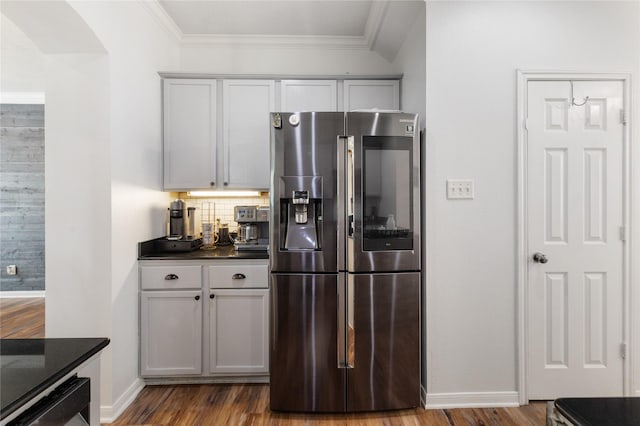 kitchen featuring stainless steel refrigerator with ice dispenser, ornamental molding, hardwood / wood-style floors, and backsplash