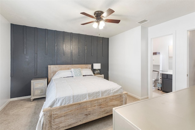 bedroom with ceiling fan, connected bathroom, and light carpet