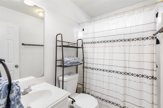 full bathroom with vanity, shower / tub combo, and toilet