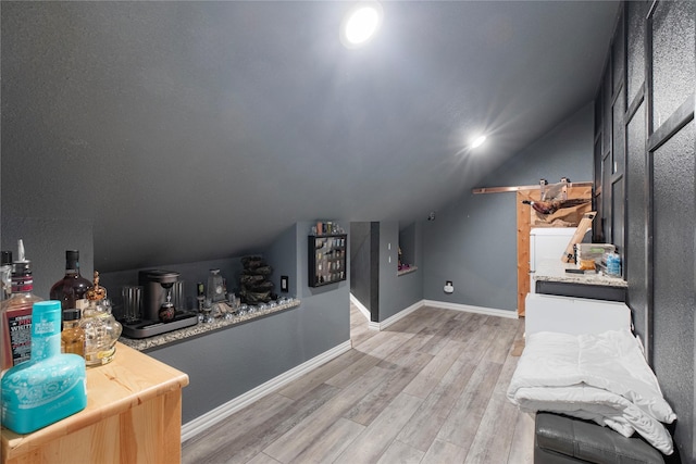 bonus room with hardwood / wood-style flooring, bar area, and vaulted ceiling