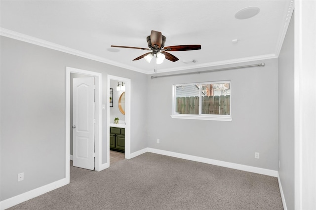 unfurnished bedroom featuring ornamental molding, light carpet, and ensuite bath