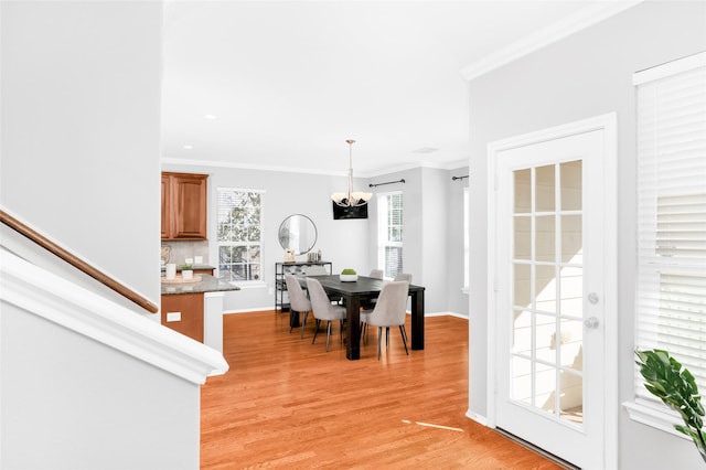 dining space with crown molding and light hardwood / wood-style floors