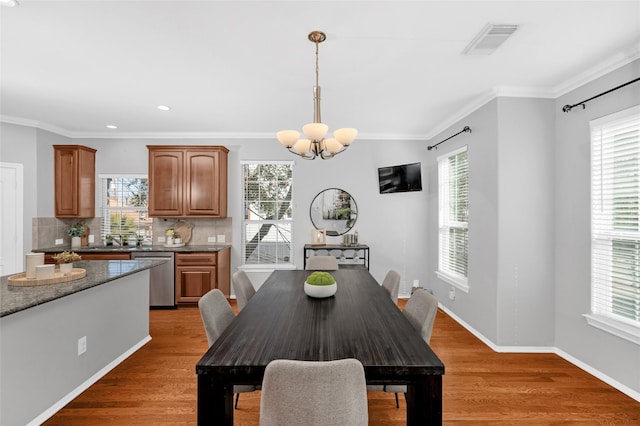 dining room with dark hardwood / wood-style flooring, ornamental molding, and a chandelier