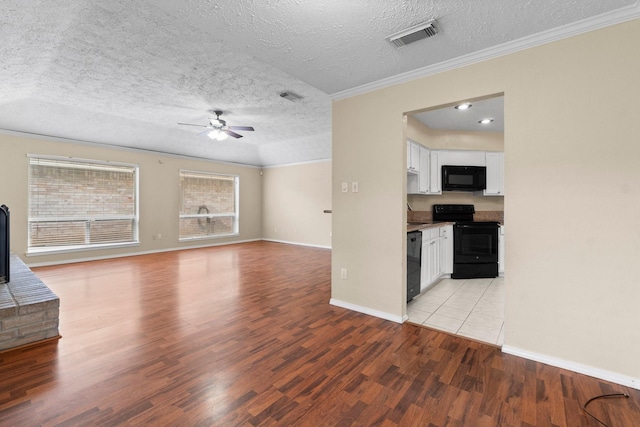 unfurnished living room featuring crown molding, a textured ceiling, ceiling fan, and light hardwood / wood-style floors