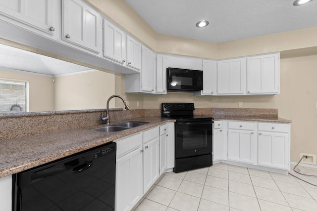 kitchen featuring sink, light tile patterned floors, white cabinets, and black appliances