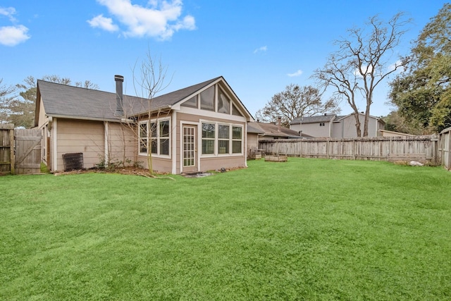 rear view of house with a sunroom and a yard