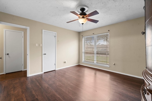 interior space featuring ceiling fan, dark hardwood / wood-style floors, and a textured ceiling