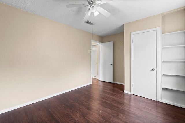 unfurnished bedroom with ceiling fan, a closet, dark hardwood / wood-style floors, and a textured ceiling