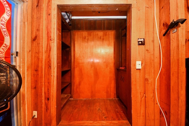 hall with wooden walls and wood finished floors