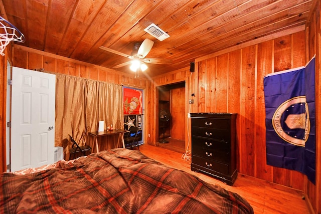 bedroom featuring visible vents, wooden ceiling, wooden walls, and wood finished floors