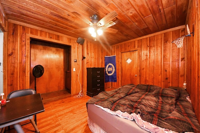 bedroom featuring wooden ceiling, light wood-style floors, and wood walls