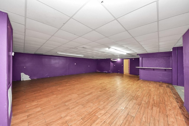 finished basement featuring a drop ceiling and wood finished floors