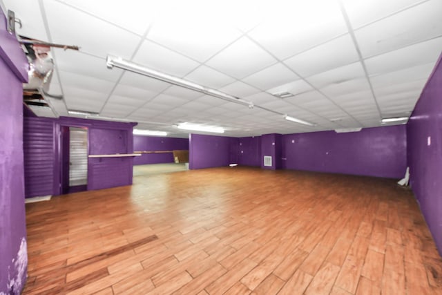 basement featuring wood finished floors and a drop ceiling