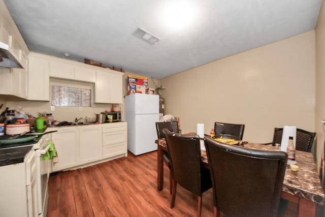 dining area with visible vents and wood finished floors