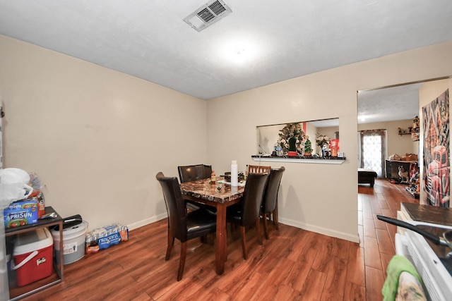 dining space featuring wood finished floors, visible vents, and baseboards