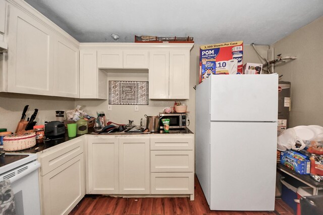 kitchen with water heater, white appliances, dark wood-style flooring, and white cabinetry