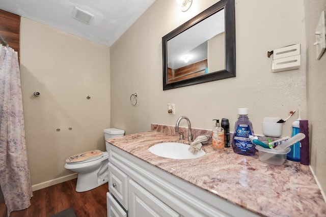 full bath featuring visible vents, toilet, wood finished floors, baseboards, and vanity