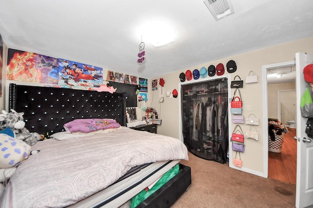 carpeted bedroom featuring visible vents and a closet