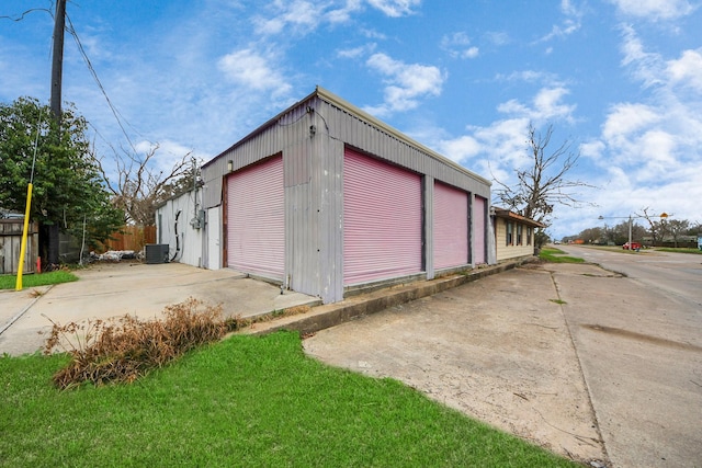 garage featuring central AC unit and fence