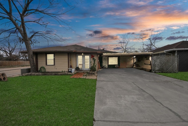 single story home featuring a carport, central AC, french doors, and a lawn