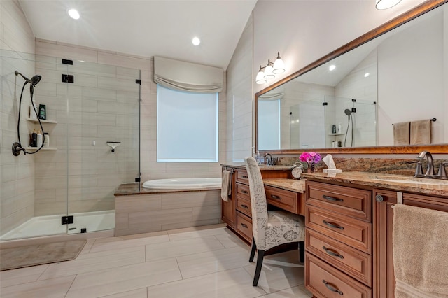 bathroom featuring vanity, vaulted ceiling, tile patterned floors, and shower with separate bathtub