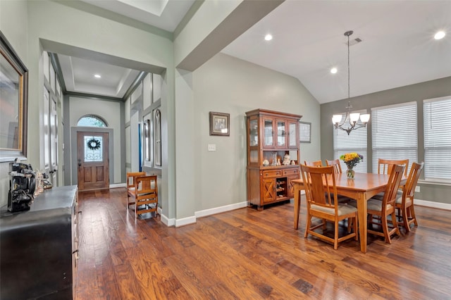 dining area featuring lofted ceiling, dark hardwood / wood-style floors, and a notable chandelier