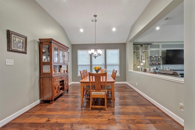 dining area with vaulted ceiling, dark wood-type flooring, and an inviting chandelier