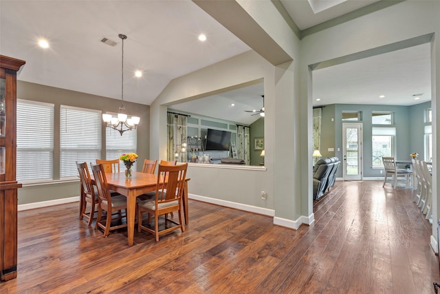 dining area featuring vaulted ceiling, dark wood-type flooring, and ceiling fan with notable chandelier