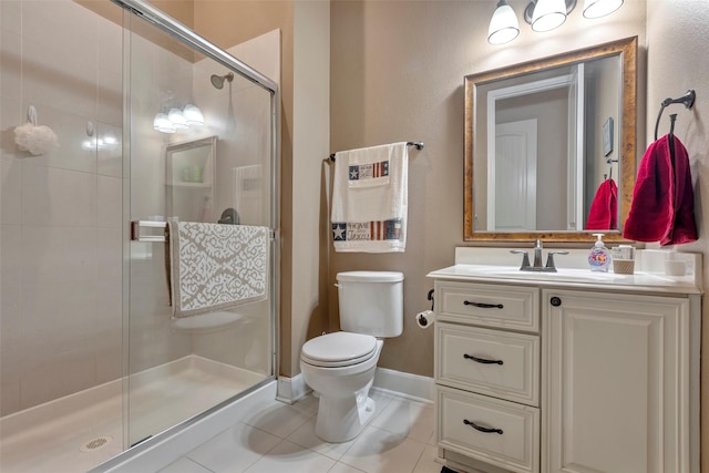 bathroom with a shower with door, vanity, tile patterned flooring, and toilet