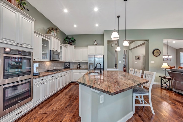 kitchen with white cabinetry, a kitchen bar, a center island with sink, and appliances with stainless steel finishes