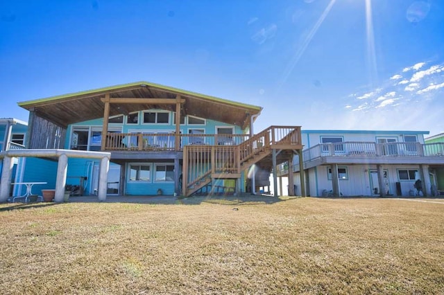 rear view of house with a wooden deck and a lawn