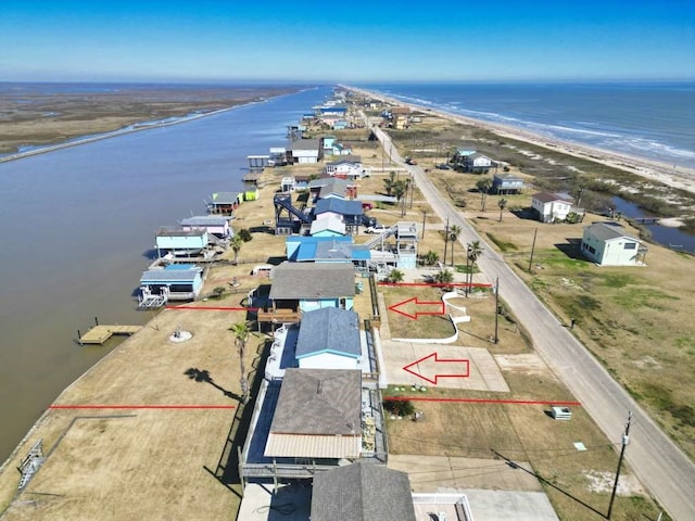 drone / aerial view with a water view and a beach view