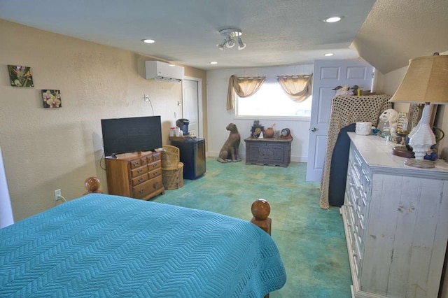 bedroom featuring a wall mounted air conditioner and a textured ceiling