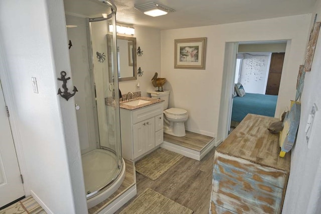 bathroom featuring hardwood / wood-style flooring, vanity, toilet, and a shower with shower door