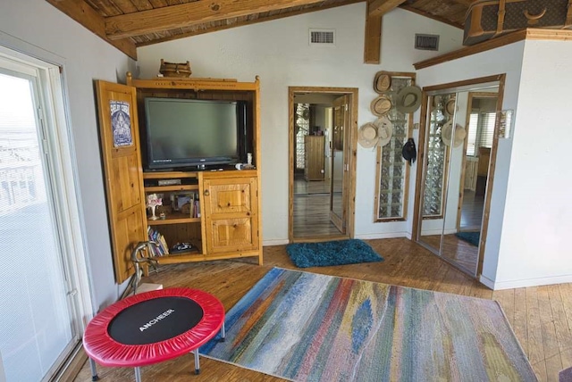 bedroom featuring lofted ceiling with beams, hardwood / wood-style flooring, and wood ceiling